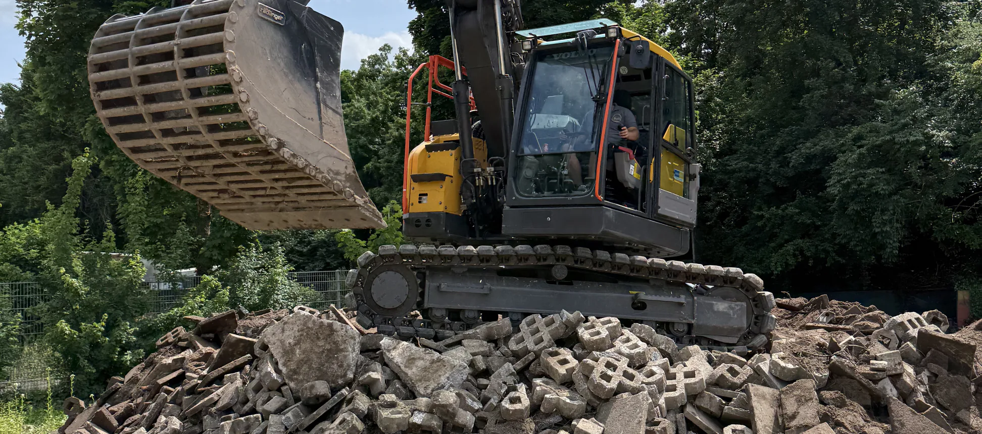 Kettenbagger von Valera mit Sortiergreifer steht auf einem Haufen aus gebrochenem Beton und Pflastersteinen